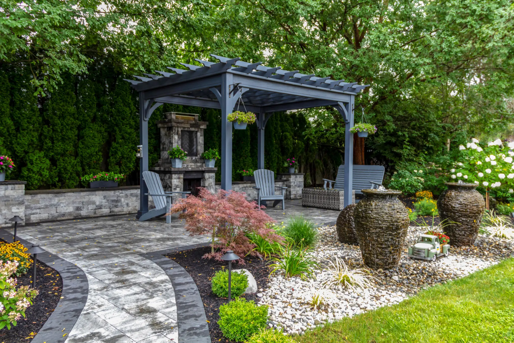 Garden pergola with chairs and decorative urns.